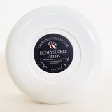 Bottom view of the white soy wax candle vessel. Fragrance Honeysuckle Fields.