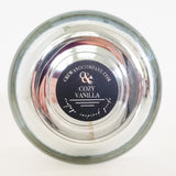 Bottom view of the chrome vessel soy candle. Fragrance Cozy Vanilla.